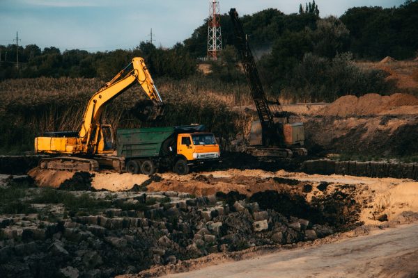 A closeup shot of an ongoing construction  with tracks and a bulldozer on an  abandoned land